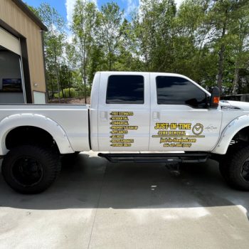 Yellow logo and services decals on the sides of Just-In_Time's truck