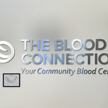 Brushed aluminum dimensional logo on lobby wall at The Blood Connection in Greenville, SC