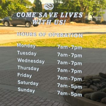Hours of Operation in white lettering on exterior doors at The Blood Connection on Woodruff Rd. in Greenville, SC