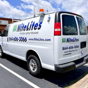Dark blue and green logo and text on white van for NiteLites of Greenville, SC