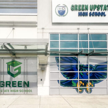 White storefront window perf with logo and mascot printed for Green Charter High School of Greenville, SC