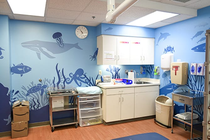 Hospital room wall wrap featuring an undersea theme of blue ocean related silhouettes at Prisma