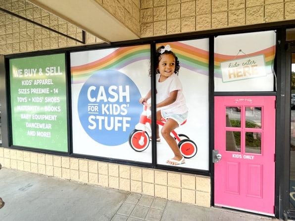 Storefront graphics showing smiling child at a kids clothing store.