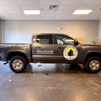 Custom cut truck decals featuring a large logo and white text for Outdoor Lighting Solutions in Greenville, SC