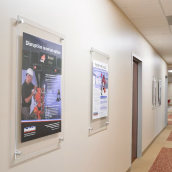 Acrylic displays installed with standoffs displaying prints about Reliable Sprinkler's safety practices at their HQ in Liberty, SC.
