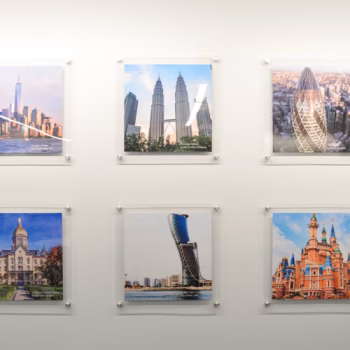 Acrylic displays installed with standoffs displaying prints showcasing buildings Reliable Sprinkler has done sprinkler work in across the world.