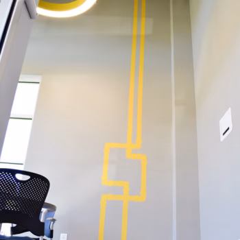 Pipe themed wall decals custom cut from yellow vinyl in the front meeting room at Vermeer's Piedmont, SC facility.
