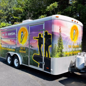 Full food trailer wrap with a mountain horizon background and logo graphics for Hey Chickadee in Hendersonville, NC.