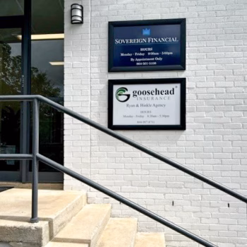 Two framed business signs next to the front door of a shared office in Greenville, SC.