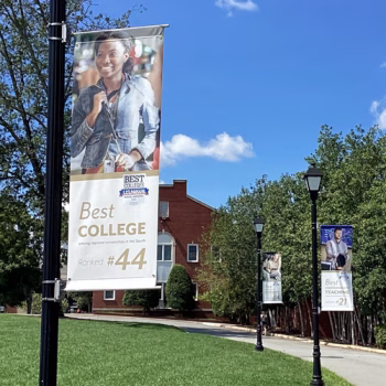 Outdoor pole banners showcasing Anderson University's accolades along their campus sidewalk.