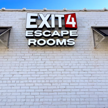 Storefront illuminated business sign on brick wall for Exit 4 Escape Rooms in Anderson, SC