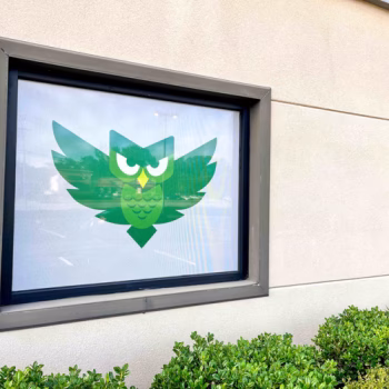 White storefront window perf with owl logo for Green Charter School of Spartanburg, SC