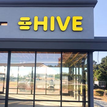 Illuminated yellow storefront logo sign for Hive in Seneca, SC.