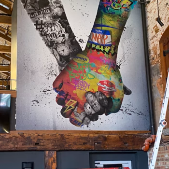 Creative wall mural with two hands holding in a brewery in down town Greenville, SC.