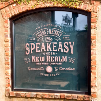 Custom window vinyl advertising the Speakeasy at New Realm Brewery in downtown Greenville.