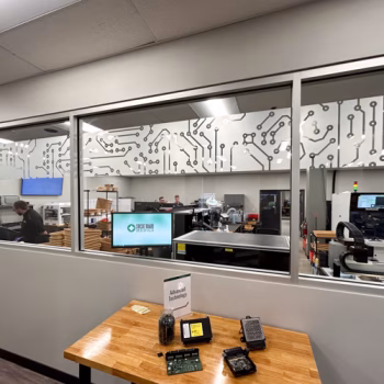 Custom cut window frosting in a circuit board pattern on windows at Circuit Board Metrics.