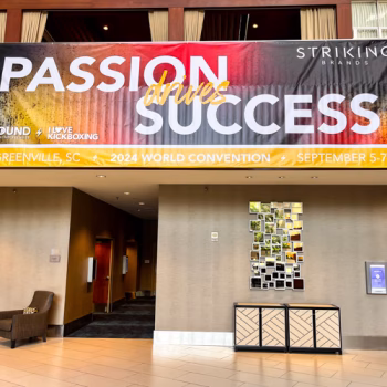 Super-format banner hanging from a second story railing at the 2024 Striking Brands convention.