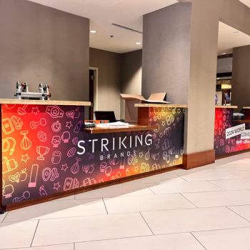 Custom, temporary check-in desk wraps for the 2024 Striking Brands convention.