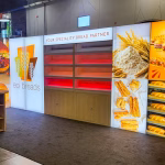 Custom fabricated tradeshow display with lighted panels, shelving and a table for EPI Breads.