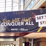 Super-format banner hanging from a second story railing at the 2024 Striking Brands convention.