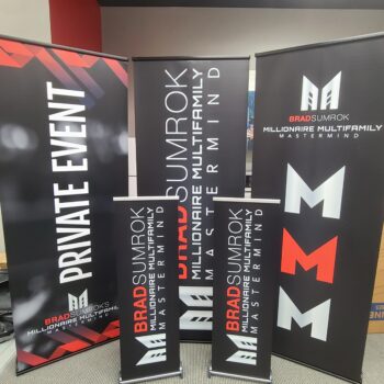 Three large and two small retractable custom banners with promotional graphics
