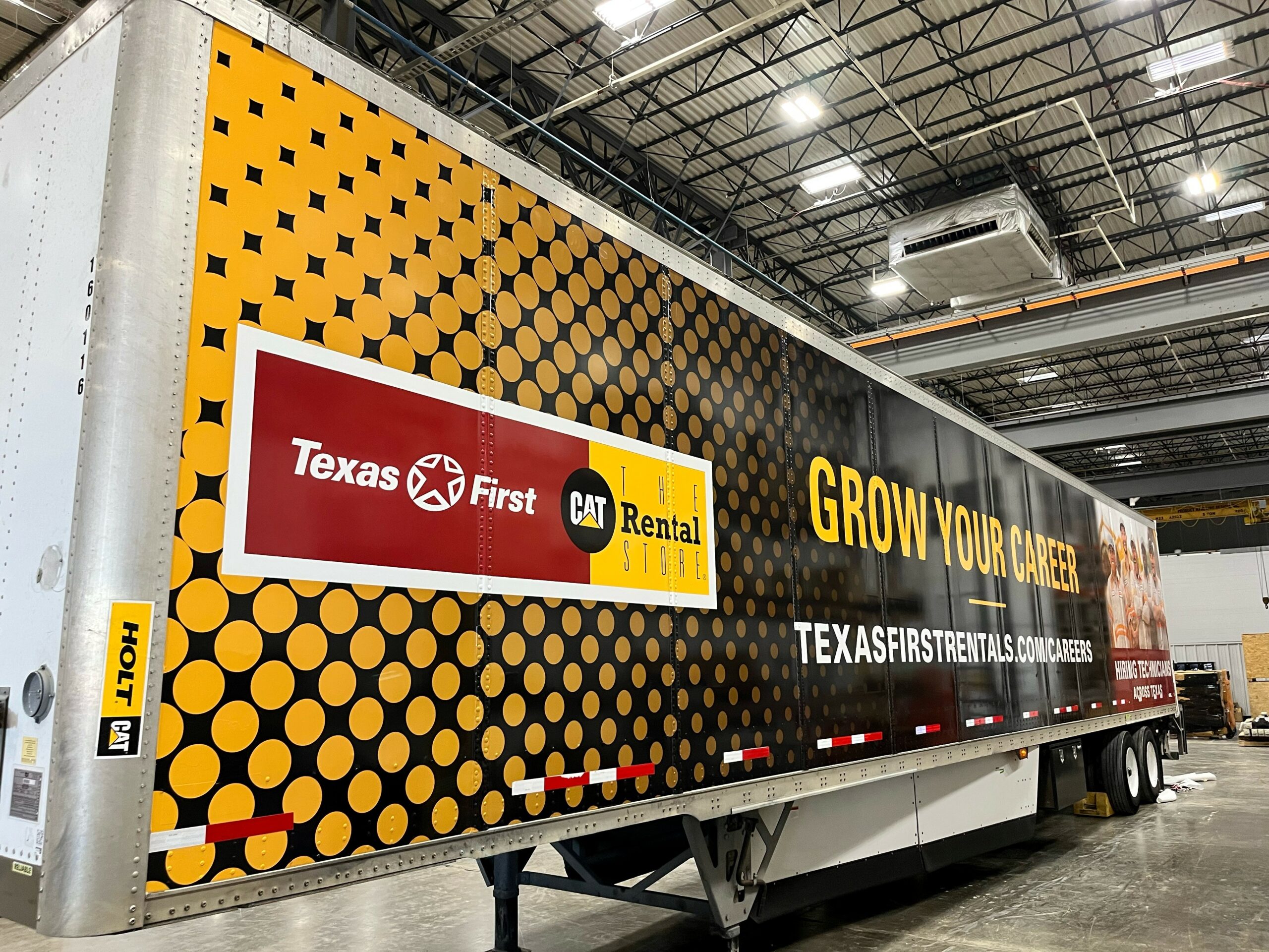Side of semi trailer wrapped in car vinyl with company logo and promotional text.