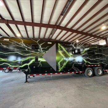 Side of a 54 foot data trailer with black panel car wrap with company logo and green lightning graphics.