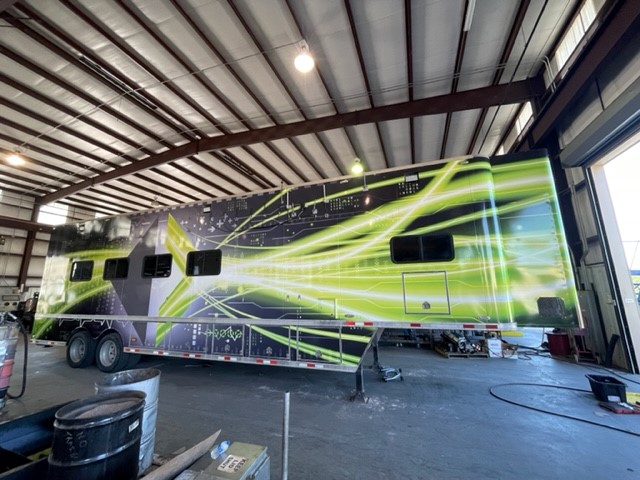 Side of a 54 foot data trailer with a panel car wrap with company logo and green graphics.