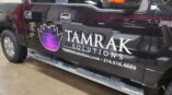 Side of a truck wrapped with vinyl company logo