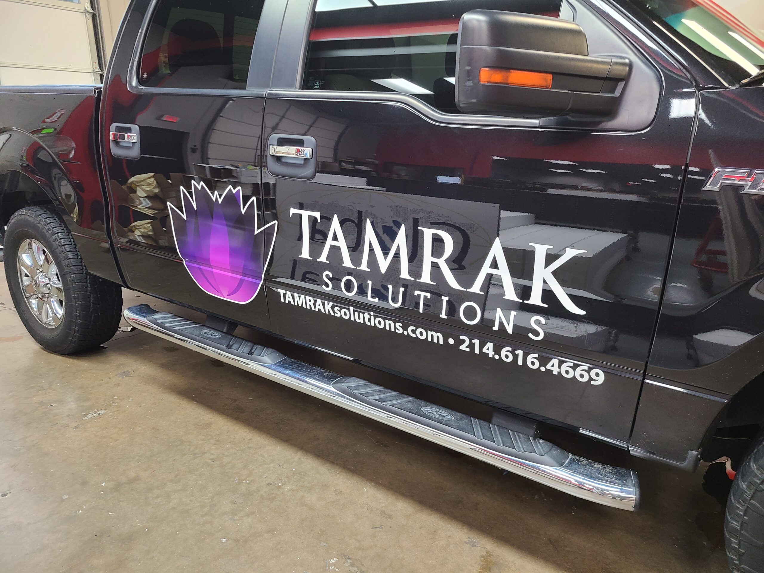Side of a truck wrapped with vinyl company logo