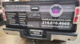 Truck bed wrapped in vinyl with informational text and company logo