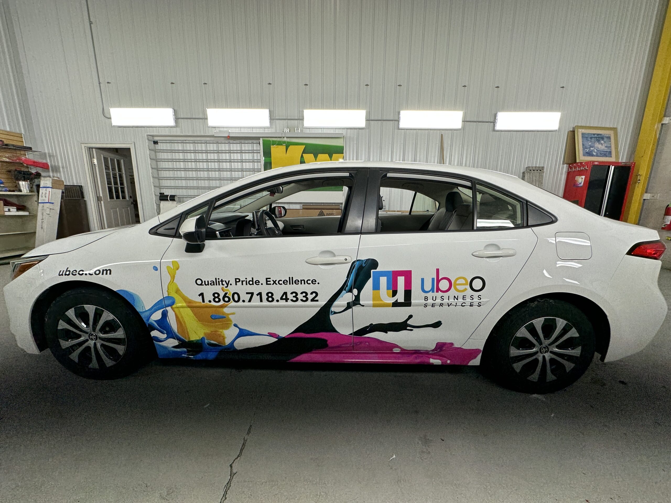 Side of a vinyl car wrap with company information and colorful graphics