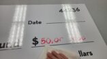 Laminated paper product for donation check presentations in action.