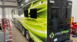 Back side of a data trailer with a panel car wrap with company logo and green graphics.