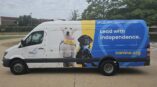 Right side of an van with graphics on it of two puppies and the words 
