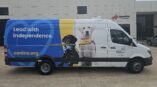 Left side of an van with graphics on it of two puppies and the words 