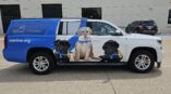 Right side of an SUV with graphics on it of three puppies for Canine Companions.