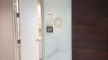 Frosted glass door with line design on wood flooring
