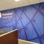 A blue wall mural in an office of architecture and the Westwood logo.