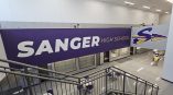Custom large format wall mural and floor graphics for Sanger High School's commercial interior, featuring purple branding by SpeedPro Irving.