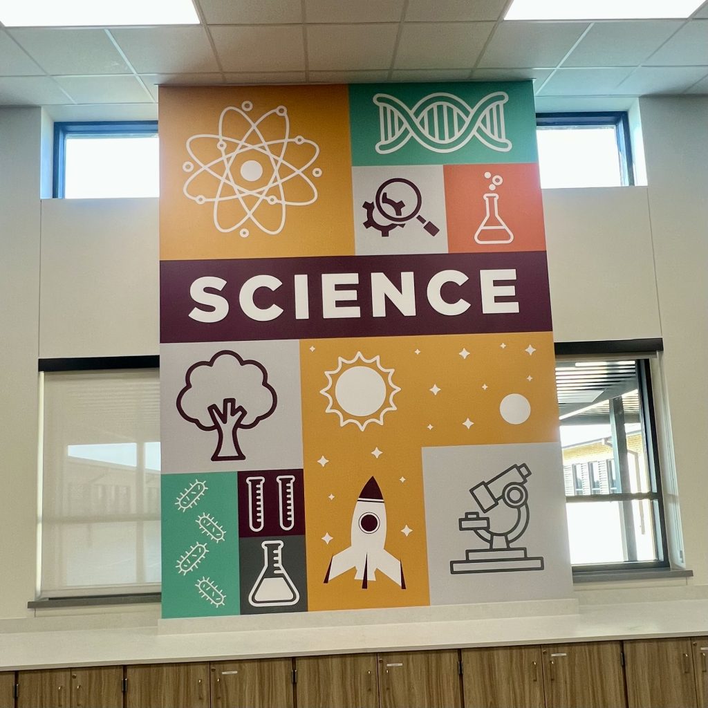 Modern science wall mural with STEM icons and bold colors in a school or educational facility