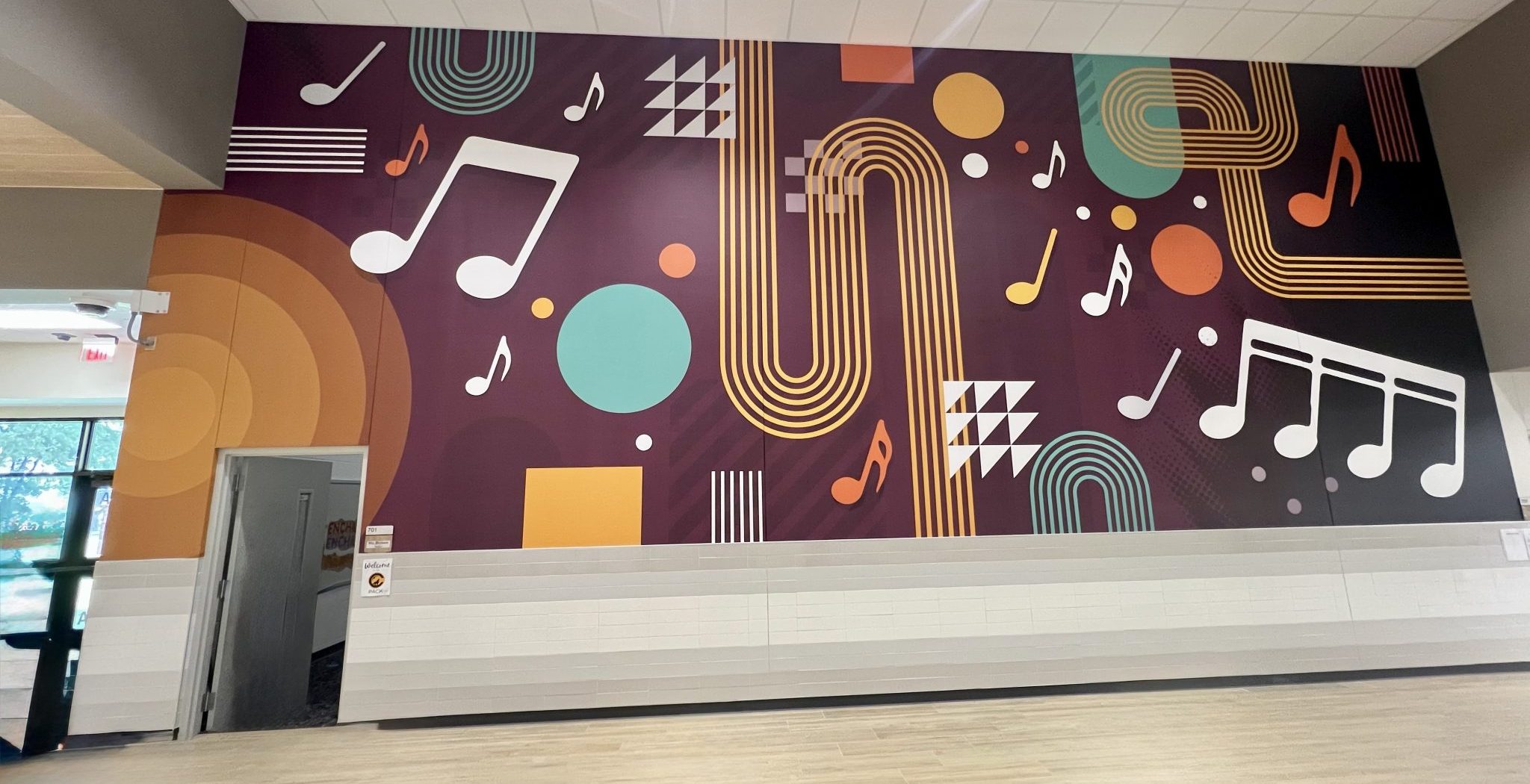 Modern music-themed wall mural with abstract instruments and notes in a contemporary interior space