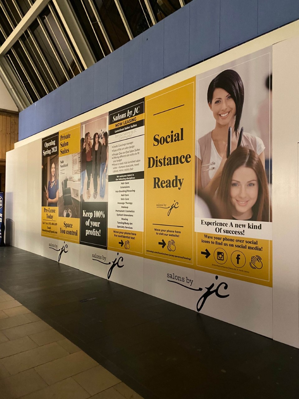 Advertising banner on a wall with posters conveying dynamic visuals and text.