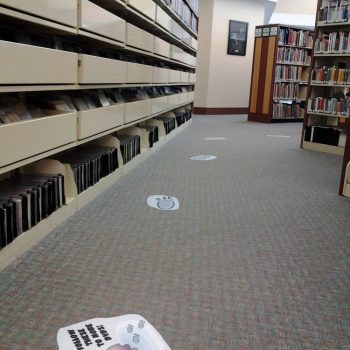 Printed floor graphics with animal paw prints and cartoon character in a library in Chicago, IL.