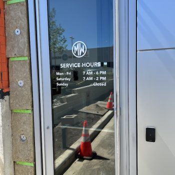 Clear vinyl window graphics with white text and logo on a glass door in Chicago, IL.