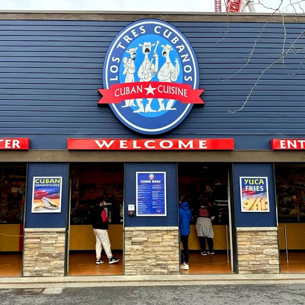 Round illuminated channel letter sign with red banner and rectangular red storefront signs in
