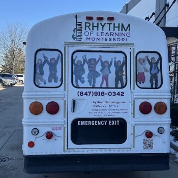 School bus rear vehicle wrap with child images and text graphics in Chicago, IL.