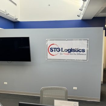 Rectangular clear acrylic wall sign with printed graphics in an office in Chicago, IL.