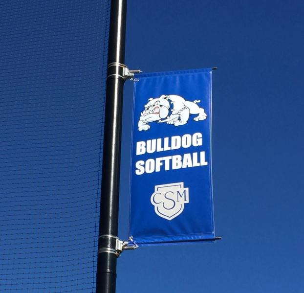Outdoor banner for Bulldog softball team, displayed on a pole at a sports venue.