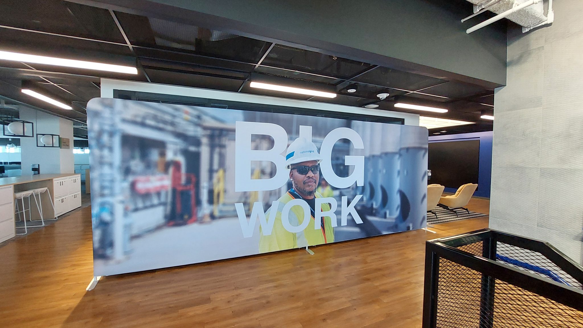Step and repeat banners fabric banner with "BIG WORK" branding displayed on a pop-up frame in a corporate office space